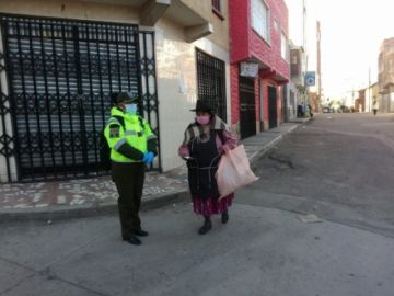 Una señora muestra su cerné de identidad.