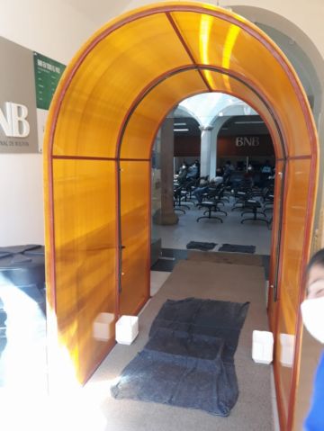 Está en la entrada a la entidad bancaria.