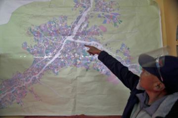 Condori señala, en un plano, el lugar donde trabaja.