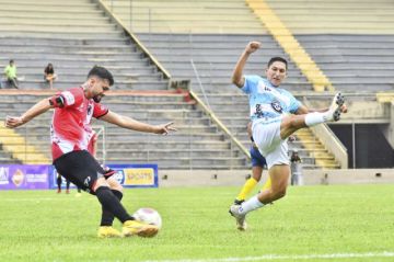 La defensa de la banda roja despeja el balón.