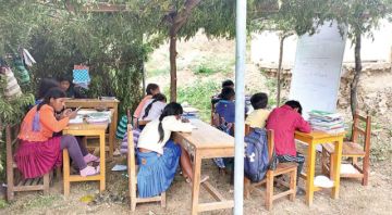 Pasan clases bajo un techo de hojas