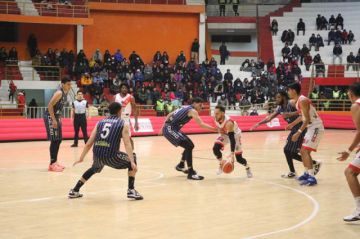 El basquetbolista Adriano Barreras, de Nacional, controla la pelota ante la marca de sus rivales.