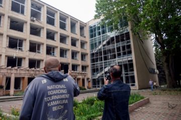 Dos personas observan los daños causados en un edificio tras un ataque ruso en Odesa, Ucrania. 