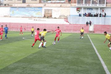 Los jugadores se disputan el balón.