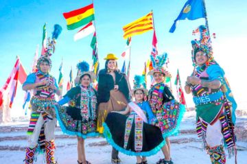 Al centro, Miss Universo rodeada de bailarines de Tinku en el Salar de Uyuni.