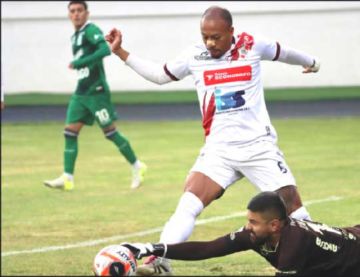 Edisson Restrepo (i) trata de esquivar al meta Luis Cárdenas.