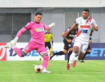 El meta Jhohan Gutiérrez despeja el esférico ante la presión de un rival.