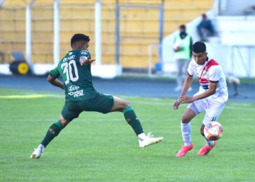 Jorge Rojas (d) trata de evitar a su marcador.