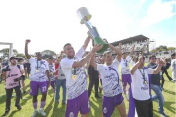 Los jugadores de Real Potosí levantan en alto el trofeo de campeón.