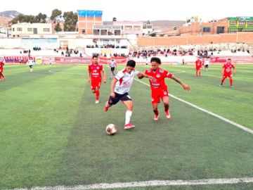 Los jugadores se disputan el balón.