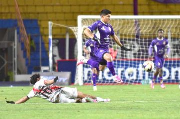 Andrés Torrico (piso) trata de detener a su rival.