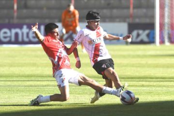 Los rivales pugnan por la posesión del balón.