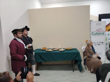 Caballeros del periodo virreinal y Adela Zamudio junto a la mesa de bocadillos potosinos.