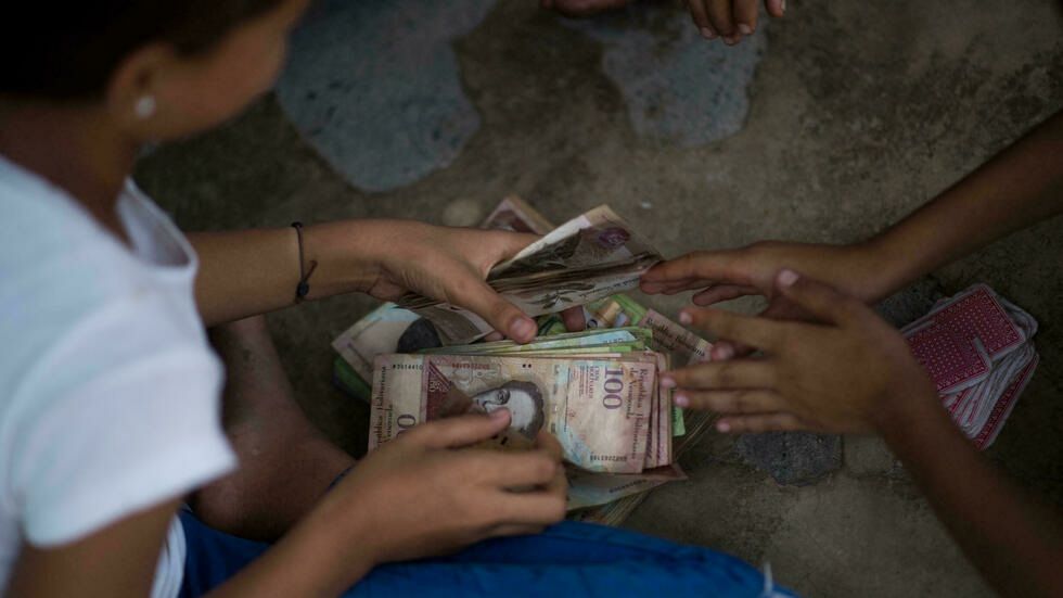 Billetes en desuso son el juguete de los niños en un pueblo de Venezuela