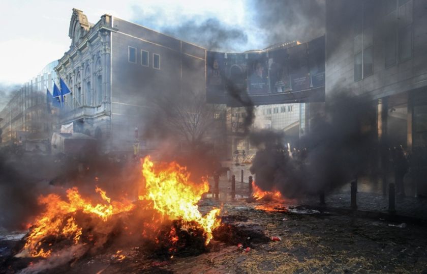 Los agricultores tumban una estatua y prenden fuego en la protesta frente a la Eurocámara