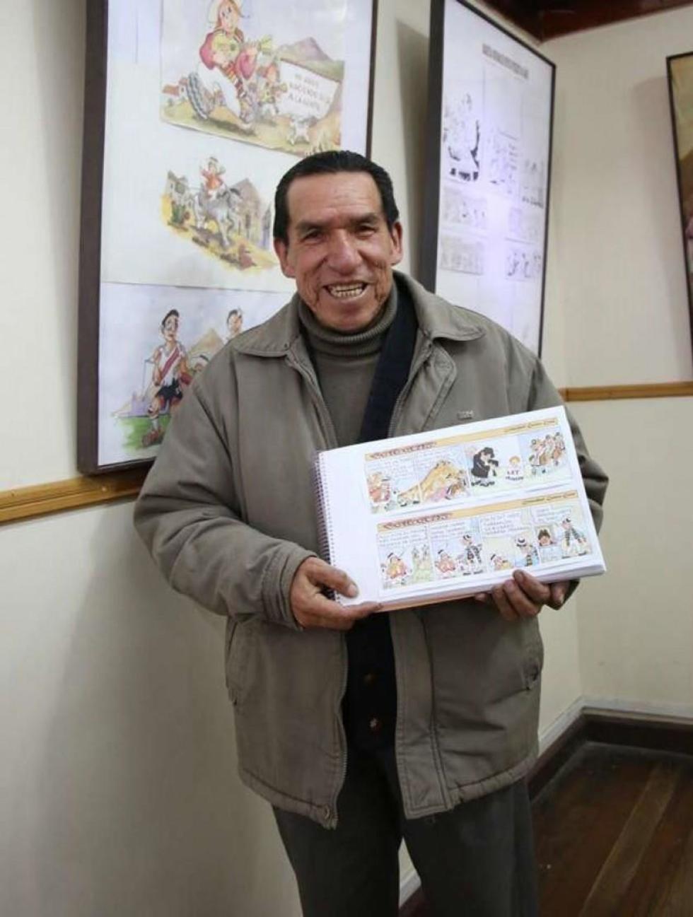 El autor delante de los cuadros y en sus manos las tiras cómicas.