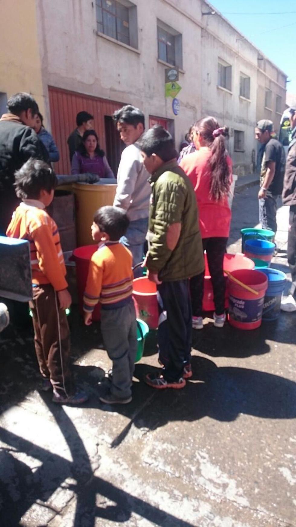 Los niños de la zona alta ayudan a recoger agua para sus domicilios.