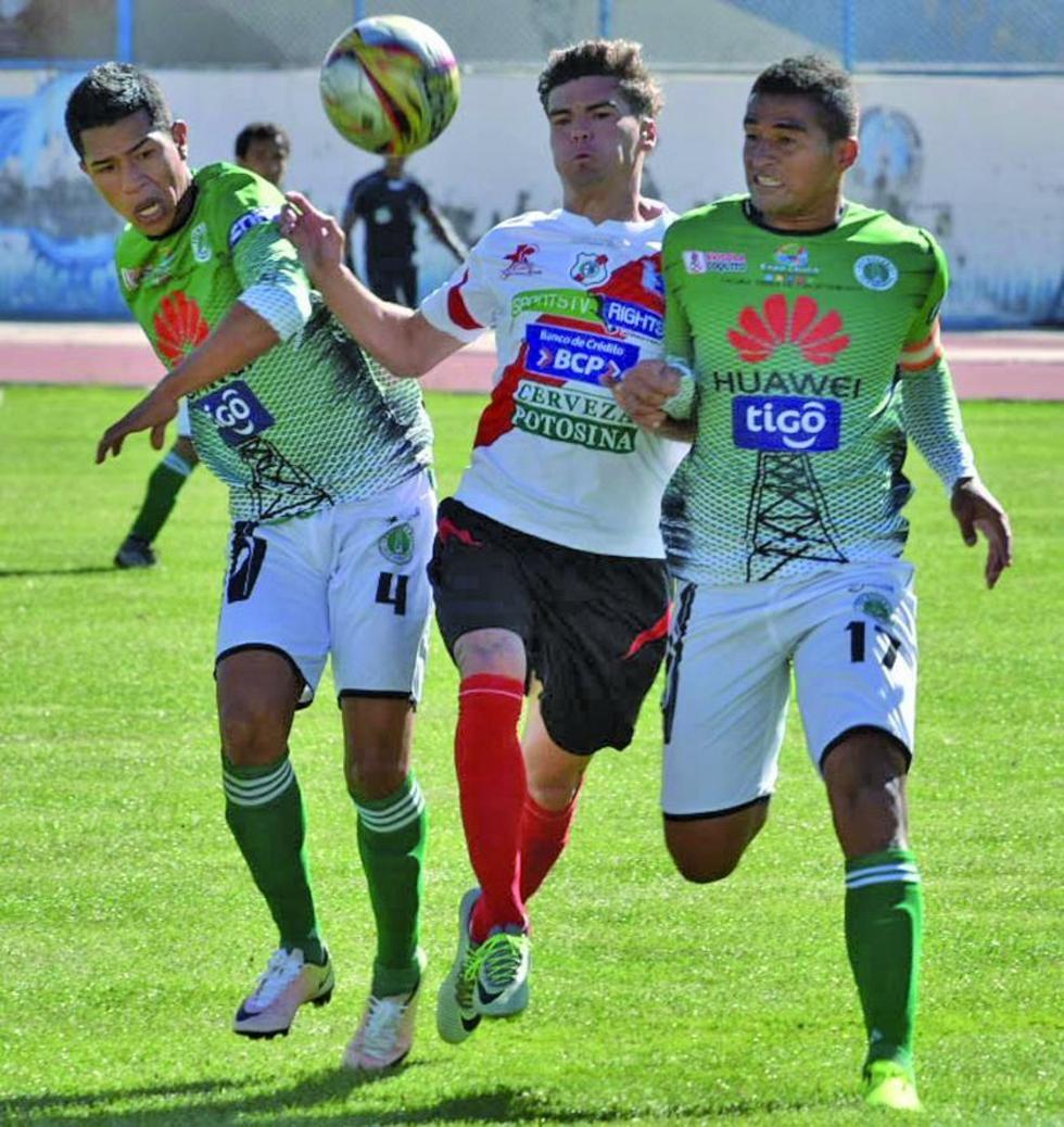 El delantero de la banda roja, Bruno Pascua, lucha por el balón ante sus dos rivales.