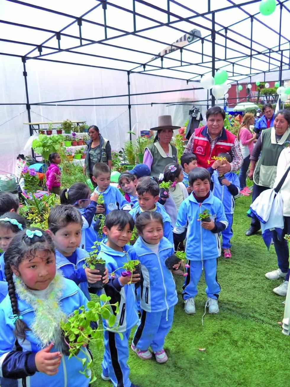 El alcalde Cervantes comparte con los niños la oferta de las flores.
