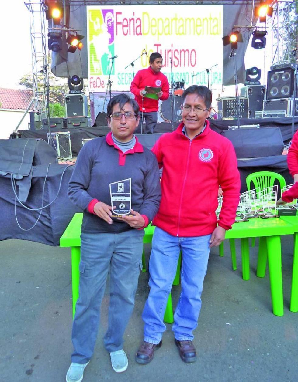 El representante de Tomave recibe la plaqueta del secretario Marco Suyo.