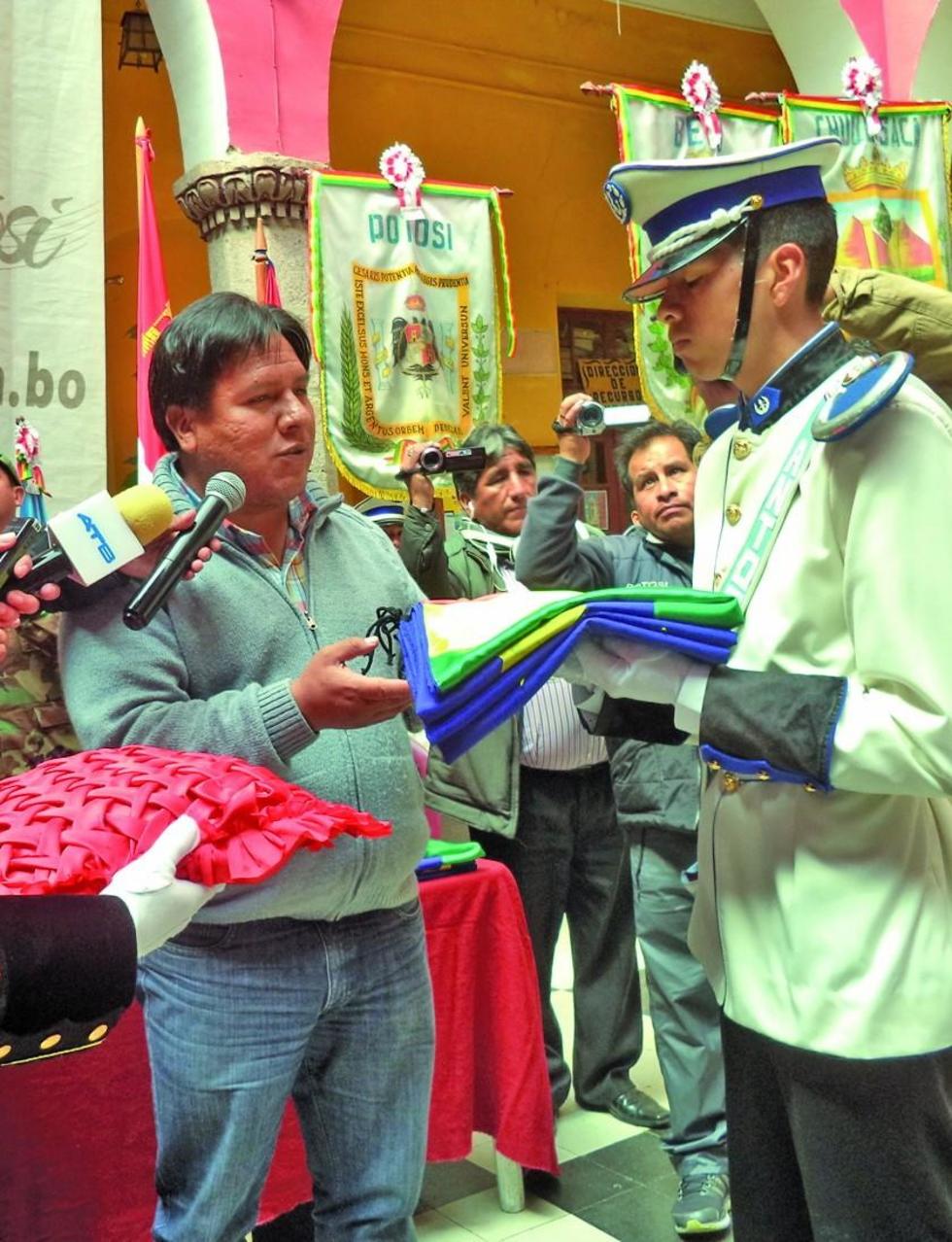 El alcalde Williams Cervantes entrega el lábaro a un estudiante.
