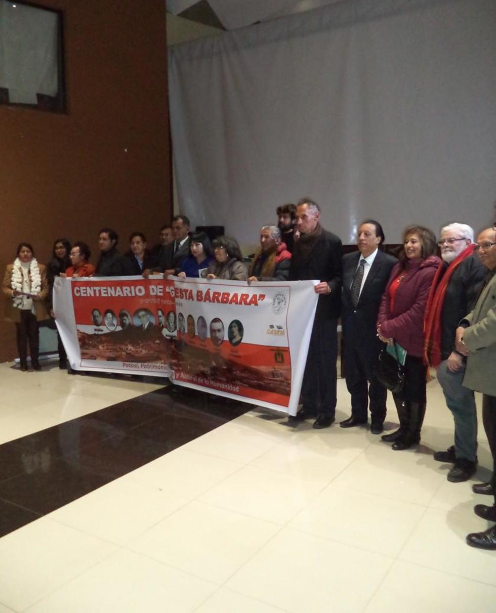 El grupo de poetas exhibe el letrero de la fiesta literaria.