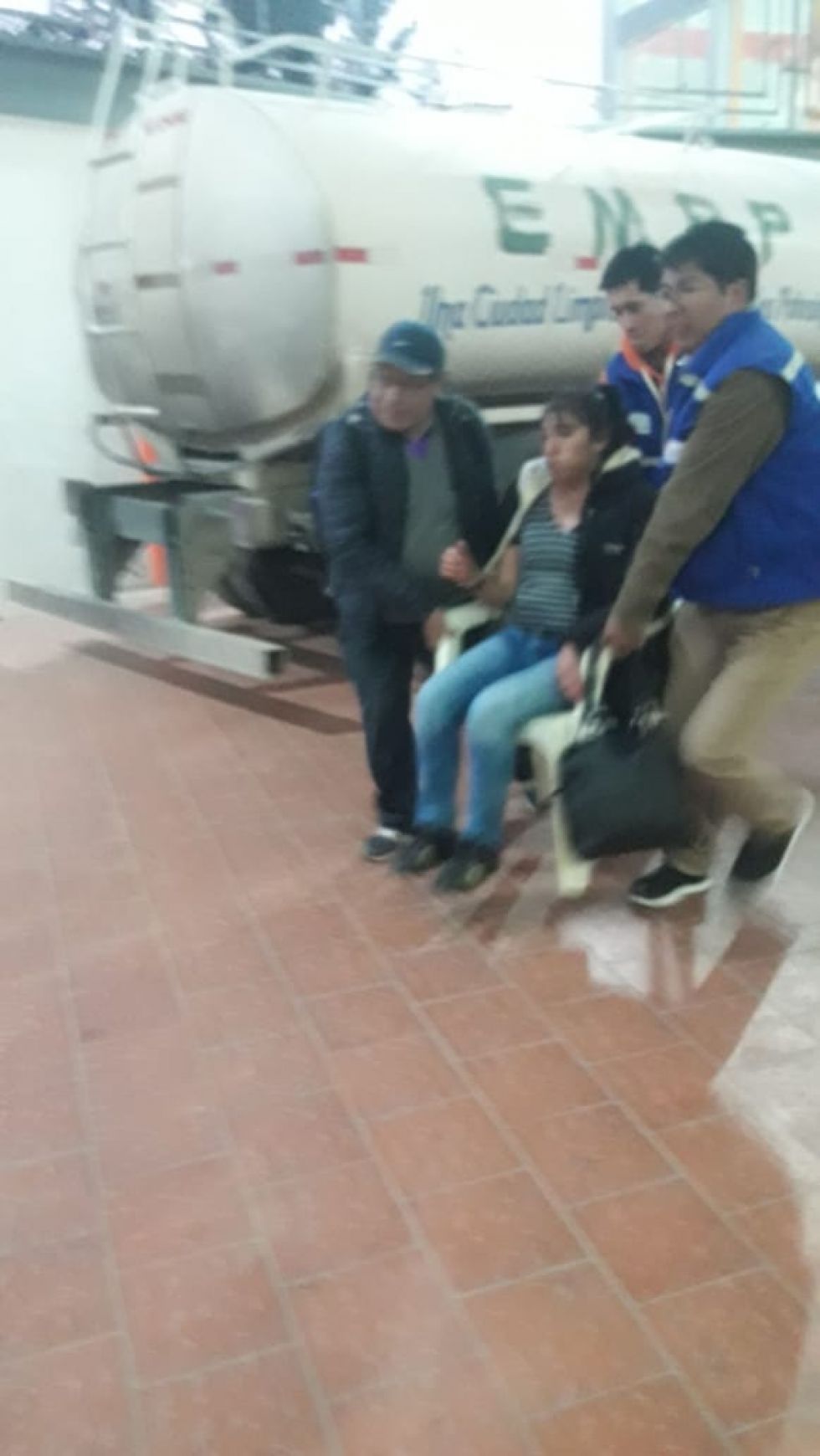 Una sanitaria es sacada en una silla.