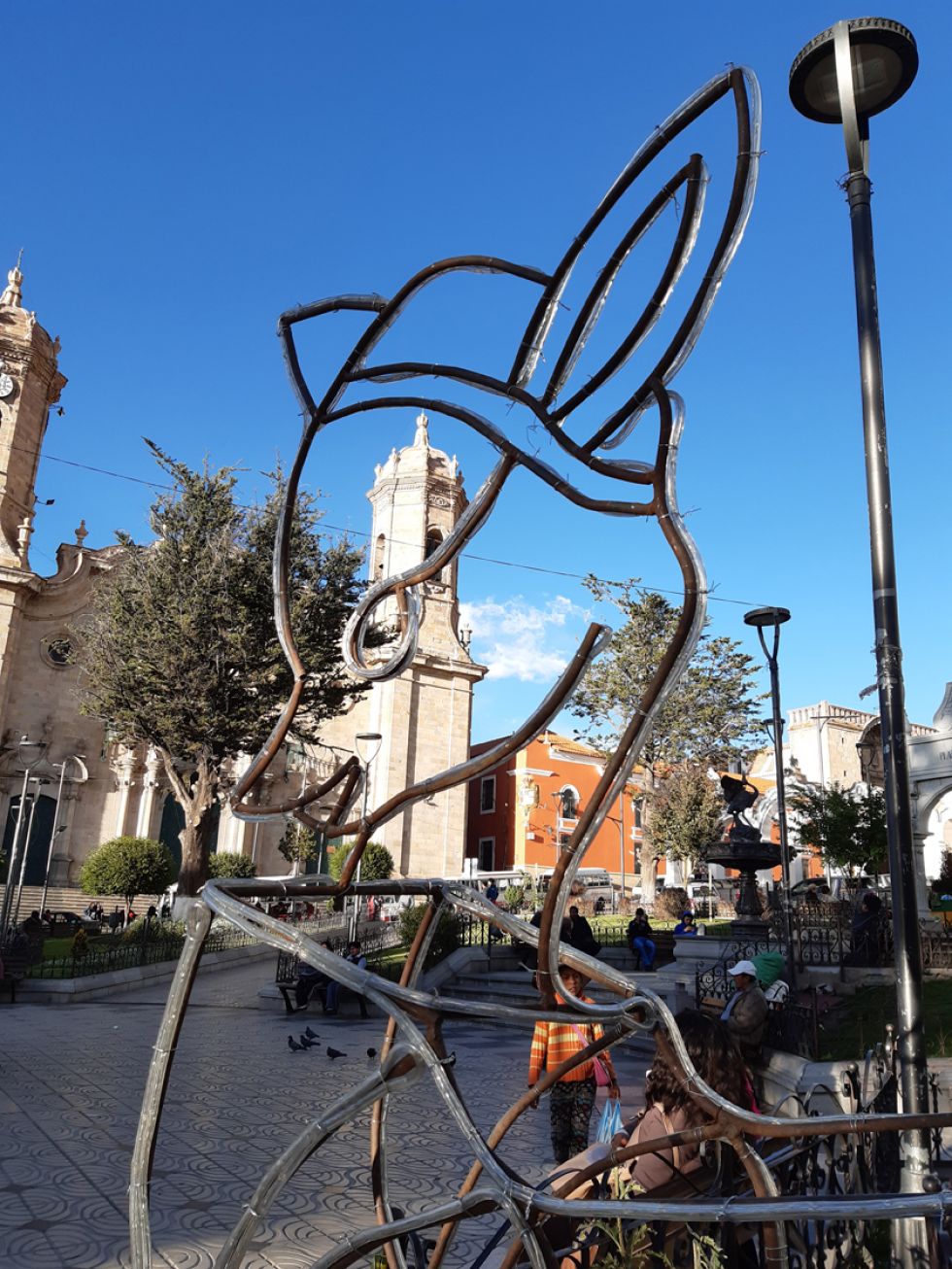 La silueta de un venado hembra se recorta con una torre de la catedral.